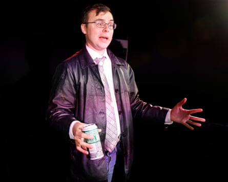 Meredith holds a can of beer and gestures on stage
