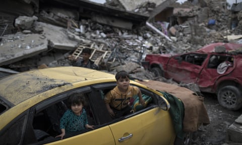 Children play inside a damaged car, amid heavy destruction in Mosul, Iraq.