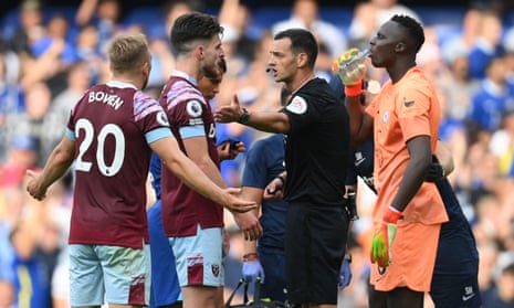 Jarrod Bowen and Declan Rice of West Ham United speak to referee Andy Madley after a VAR decision ruled out a goal by Maxwel Cornet at Chelsea.