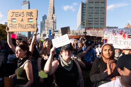 people hold signs including one saying ‘jews for a free palestine’ and another saying ‘ceasefire, free palestine’