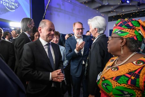 German Chancellor Olaf Scholz speaks with World Trade Organization Director-General Ngozi Okonjo-Iweala (right) as he left the stage after his speech