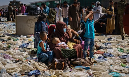 A woman is surrounded by her children as she sits amid a pile of debris in the processing area towards Abbey gate on Wednesday