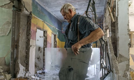 Maintenance worker Anatolii Slobodianik salvages a piece of glass from the rubble of the Kramatorsk College of Technologies and Design, after it was hit in an early morning rocket attack in Kramatorsk, in the Donetsk region of eastern Ukraine, Friday, Aug. 19, 2022. (AP Photo/David Goldman)