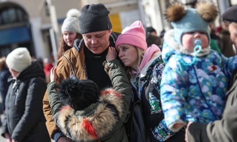 Oleh Kyshynsky hugs his wife Iryna and daughter Ksenia while Oleh’s father-in-law Victor carries their son Constantin at the central railway station in the southern Ukrainian port city of Odesa, Ukraine, 20 March 2022.