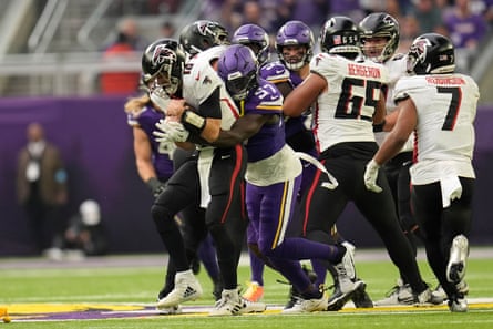 Atlanta quarterback Kirk Cousins (18) is sacked by Minnesota linebacker Jamin Davis (57) during a December game.