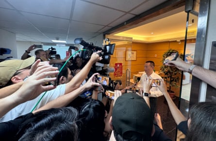 Journalists gather around Gold Apollo founder and chief executive Hsu Ching-kuan at the door of the company’s office in New Taipei City on Wednesday.