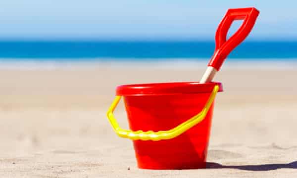 Red Bucket and Spade on Beach Holiday Vacation Concept<br>A4FM5B Red Bucket and Spade on Beach Holiday Vacation Concept