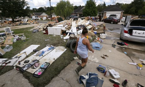 A resident walks through a flood-damaged neighborhood in Louisiana. The state’s governor has requested an addition $2 bn in emergency aid from the federal government. “Simply put, we cannot recover without it,” Edwards said at a House subcommittee hearing.