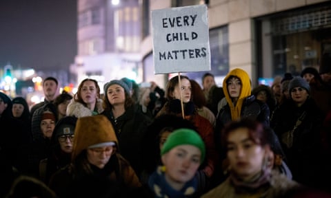 Protesters gather under a placard that reads: 'Every child matters'