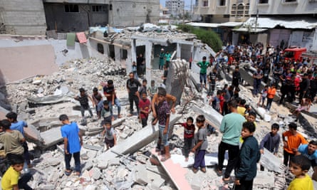 Palestinians search the rubble of a building that was destroyed in an Israeli airstrike