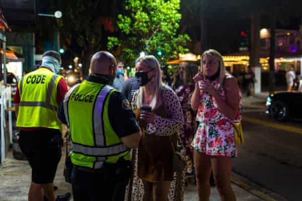 Police Officer Randy Perez (c) inform people about wearing protective face masks in the downtown area of Duval Street in Key West, Florida on September 18, 2020.