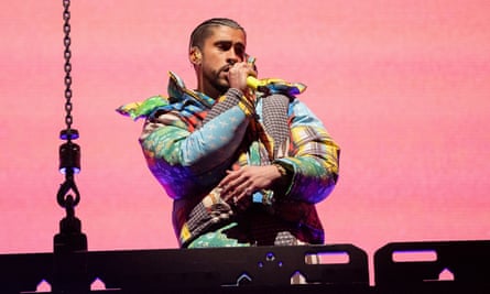 A person wearing a colorful jacket sings into a microphone onstage