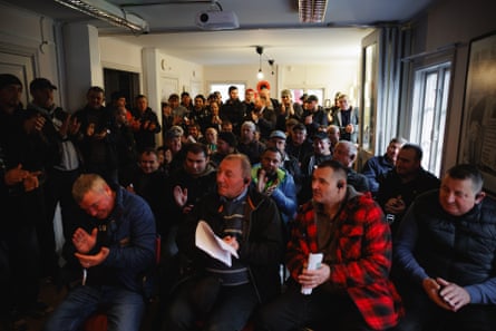men in a meeting applauding and holding agenda papers