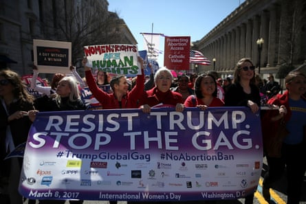 Protesters hold signs as they march to the White House during a march and rally to support women’s health programmes and protest the White House global gag rule on March 8, 2017 in Washington DC.