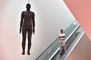 London, England: British artist Antony Gormley poses for a photograph next to his artwork entitled Object, 199, a life-size iron sculpture cast from the artist’s body and hung from the ceiling of the National Portrait Gallery