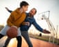 Father and son playing basketball on outdoor court