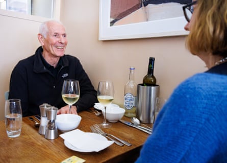 A man and woman facing each other across a restaurant table