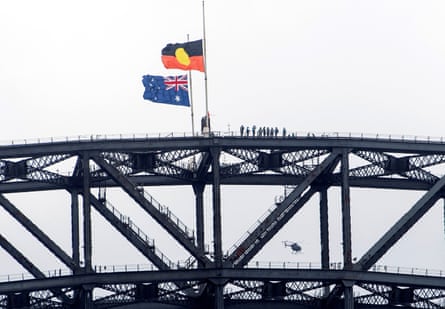 The Australian flag and the Aboriginal flag flutter at half mast on the Sydney Harbour Bridge on Thursday during a national day of mourning for the victims of the Bondi beach mass shooting.