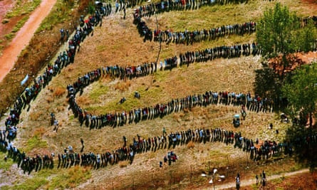People queue at a primary school to cast their votes at a polling station in Soweto, South Africa, as the country went to the polls 27 April 1994.