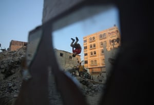 A young man practises parkour over the rubble of destroyed houses in the southern Gaza Strip