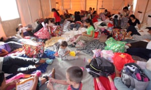 Central American mothers and their children take a place on the floor of a portable tent at the Humanitarian Respite Center Sacred Heart Catholic church in McAllen, Texas, earlier this month.