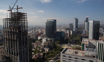 A crane sits on top of a partially constructed building on Reforma Avenue in Mexico City