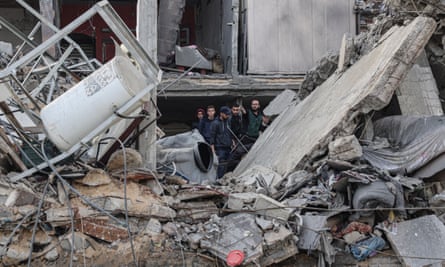 People searching in the rubble of homes destroyed by an Israeli airstrike in Rafah.