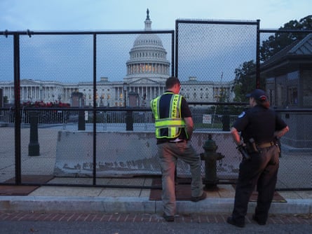 Capitol police officers look over the integrity of the fence put up to secure the US Capitol and its grounds before Saturday’s rally.