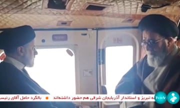 Raisi (L) with a member of his delegation on a helicopter in East Azerbaijan