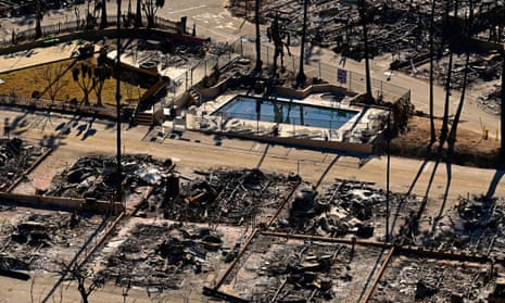 A swimming pool sits amid charred homes and burnt cars in the rubble of the fire-ravaged Pacific Palisades in Los Angeles.
