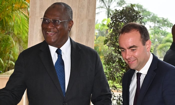 French Minister of Armies Sebastien Lecornu (R) is welcomed by Ivory Coast’s Minister of defence Tene Birahima Ouattara (L) ahead of their meeting in Abidjan on July 16, 2022.