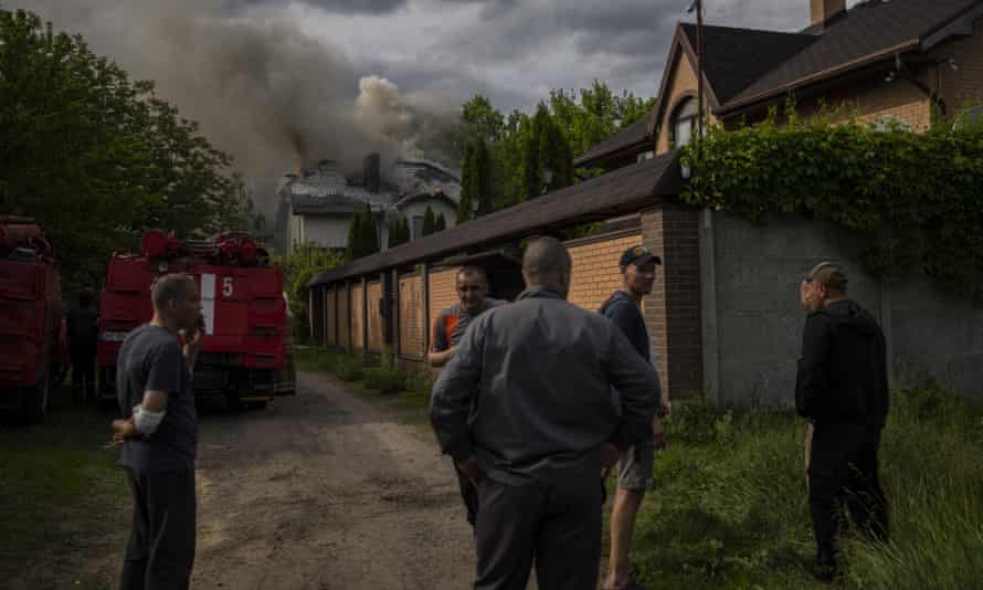 Neighbours gather around a house on fire that was hit during a Russian attack with a cluster-type munition in Kharkiv, eastern Ukraine, Monday, May 30, 2022.