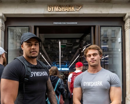 Two muscular men in tight black and gret Gymshark T-shirts outside the brand’s store on Regent Street in London.