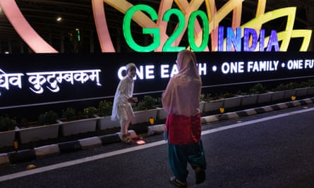Children pose in front of the G20 logo outside the Bharat Mandapam stadium in New Delhi.