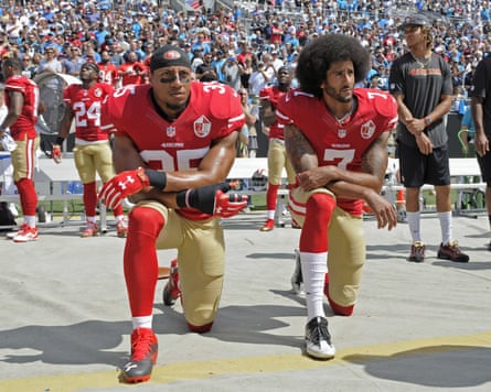 Two American footballers on one knee at the stadium