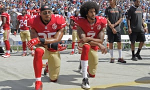 Colin Kaepernick, right, and Eric Reidkneel during the national anthem before an NFL football game in protest against police brutality.