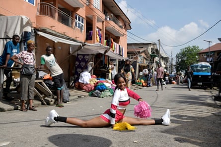 A member of the Lagos Cheer Nigeria cheerleading team, doing the splits in a street
