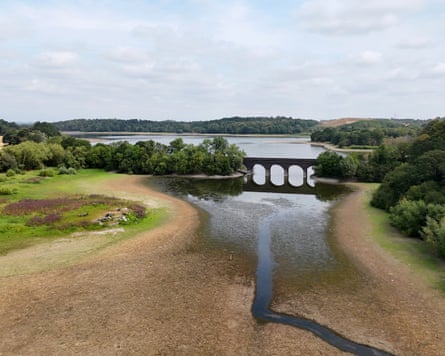 A partially dry lakebed, crossed by a railway bridge