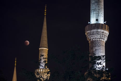 The blood moon appears to dangle between minarets in Istanbul, Turkey.