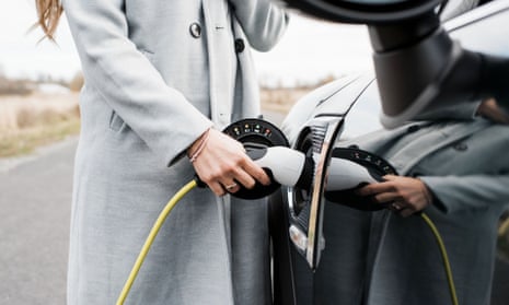 A woman charges her electric vehicle. Electric carmarking operations of companies like Toyota, Volkswagen and BMW are likely to become more profitable than traditional arms of the company, modelling suggests.