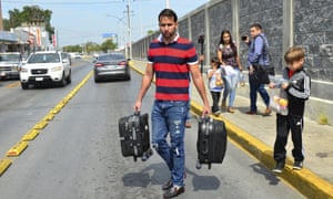 The Ascencio family, from Venezuela, carry their luggage after being returned by US authorities to Nuevo Laredo, Mexico as part of the first group of migrants to be sent back under the so-called Remain in Mexico program for asylum seekers this month.