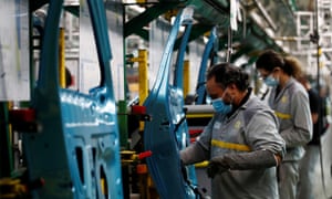 Employees wearing protective face masks work on a Renault assembly line in France.