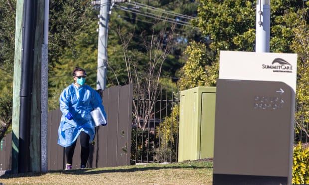 A person in PPE arrives at SummitCare aged care facility in Sydney’s Baulkham Hills on Sunday after it was revealed three residents had tested positive to Covid-19. Two staff members were infected last week.
