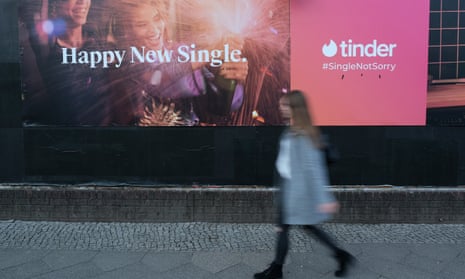 Woman walking past Tinder billboard