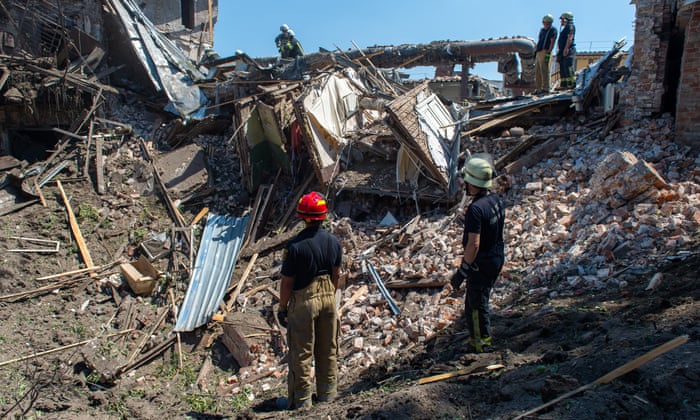 Rescuers sort through the rubble of an apartment building after a Russian missiles hit a residential building in Kharkiv, Ukraine