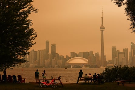 People look toward skyline of Toronto through hazy, polluted air from the Toronto Islands