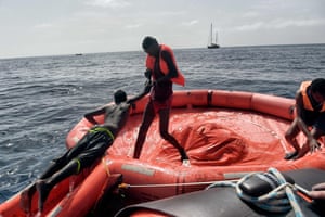 A man helps another into one of the Proactiva Open Arms rescue inflatables