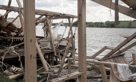 A destroyed veranda and seating next to a lake