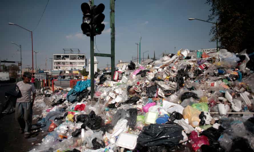 A man walks past piled rubbish in Mexico City.