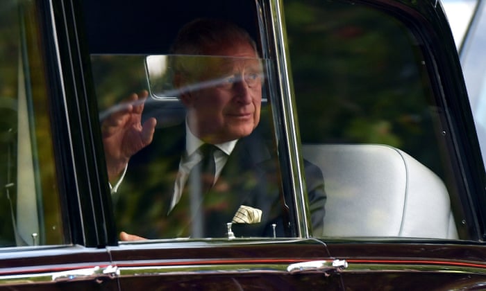 King Charles III waves to the crowds as he is driven along The Mall to Buckingham Palace.